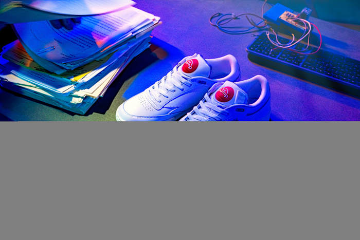 Overhead view of white and red Reebok shoes.